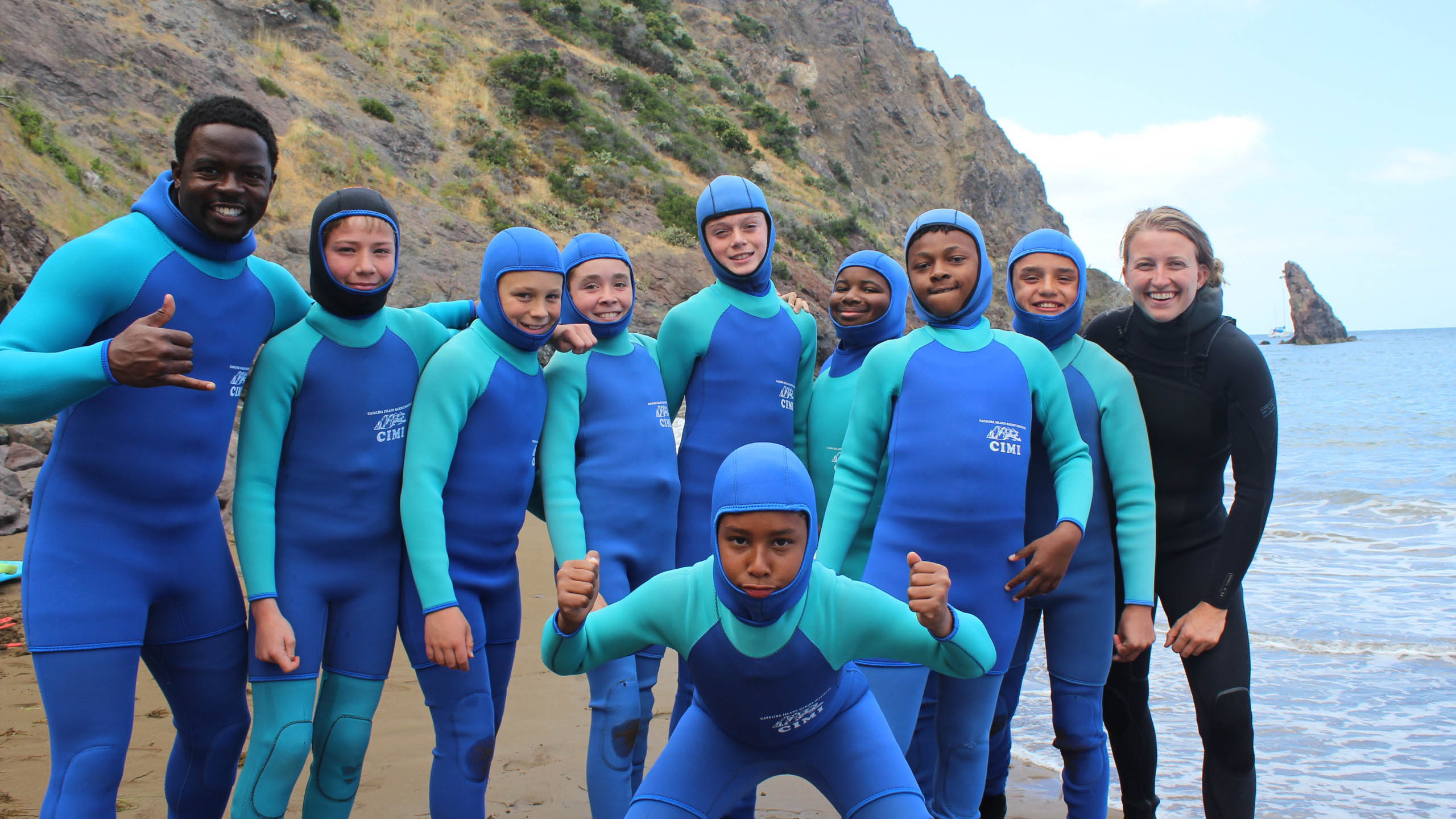 Group posing in wetsuits.