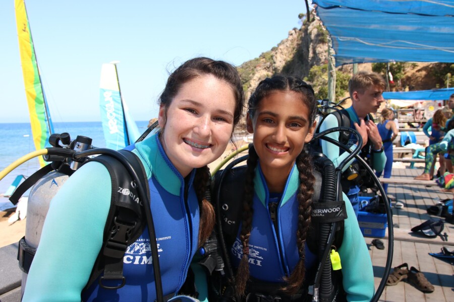 Two girls smiling in scuba gear.